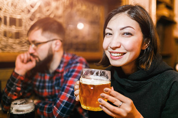 A woman and her friends try freshly brewed authentic Czech beer in a tavern in Prague