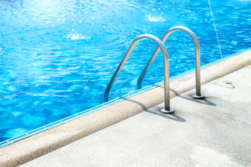 Grab bars ladder in the blue swimming pool