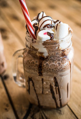 Chocolate milkshake with marshmallow. Chocolate dessert. Wooden background.