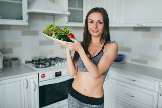 Girl preparing and eating salad after fitness training.