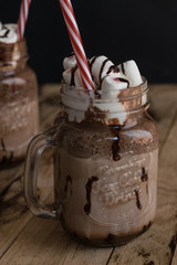 Chocolate milkshake with marshmallow. Chocolate dessert. Wooden background.