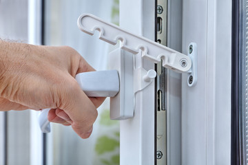 Men's hand opens a plastic window with stop turning.