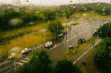 photo of  water drops on window glass with abstract green bokeh background in summer day.