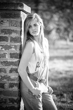 Senior photo of a young woman on a farm wearing farm style clothing