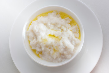 Healthy food - rice porridge with milk on a white plate