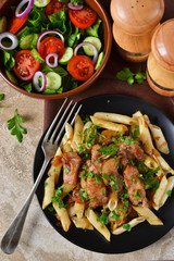 Homemade penne pasta with sauce and chicken for dinner on a concrete background