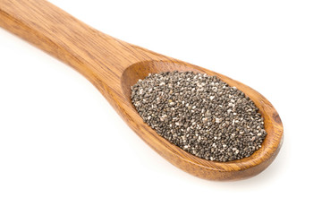 Whole dried black chai seeds in wooden spoon