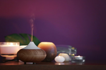 Aroma oil diffuser and candles on table