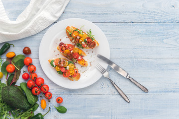Bruschetta with cheese, basil, arugula and cherry tomatoes
