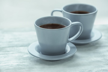 Cups with hot tea on wooden table, closeup