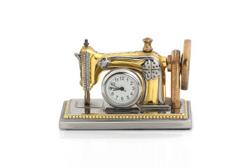 Decorative clock in the form of an old sewing machine on a white background. Isolated