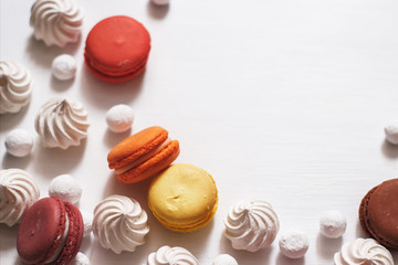 White background with meringue, macaroons and cranberries in sugar