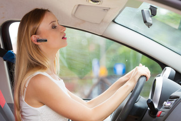 woman driving car with headset