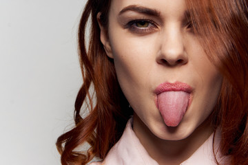 beautiful red-haired woman showing tongue