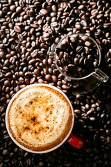 A cup of cappuccino on coffee beans