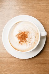 A cup of cappuccino on wooden table