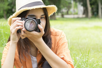 young woman sit on green grass enjoy with camera Outdoors, photographer and Relax concept