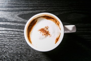 A cup of cappuccino on wooden table