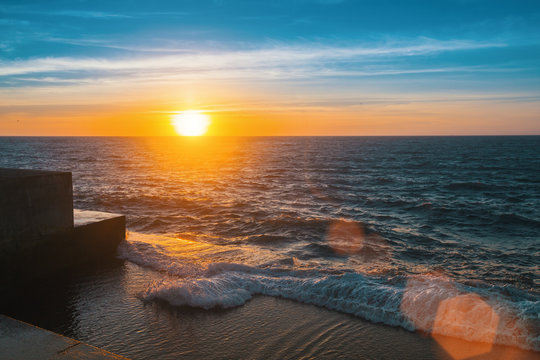 Fototapeta Wonderful sunset at the sea pier, flare and rays.