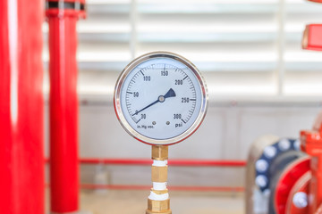 View of fire water pump pressure gauge installed on a red pipe for fire emergency system industry.