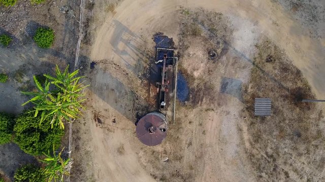 Aerial view from a drone of oil pumpjack (sucker rod beam) in the field on sunny day
