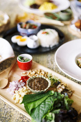 Fried Mackerel served with Fresh Vegetable and peanut Brittle Dressing on wooden background