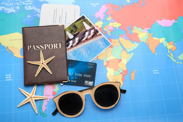 Credit card with passport and ticket for vacations on world map background