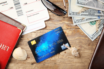 Credit card with money and passports on wooden background