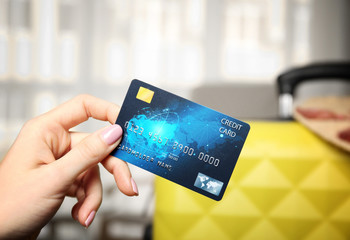 Female hand holding credit card on blurred background