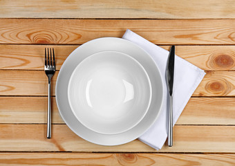Beautiful table setting with white plates on wooden table