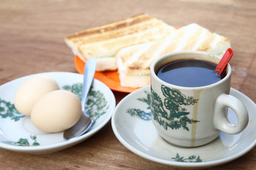 Breakfast set of half boiled eggs, toast and coffee, popular meal in Malaysian and Singaporean coffeeshops