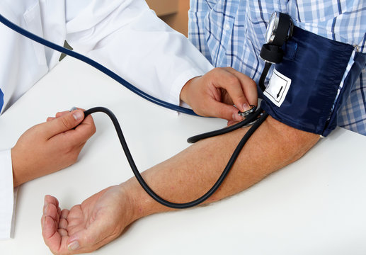 Doctor measuring blood pressure with sphygmomanometer