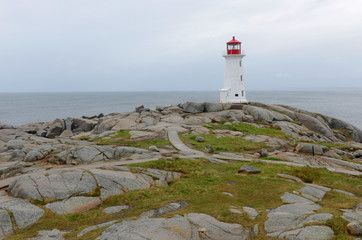 Peggys Point Lighthouse in cloudy in historic Peggy`s Cove, Nova Scotia, Canada. The lighthouse was...