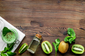 Skin care cosmetic with kiwi scrub on desk background top view mock-up