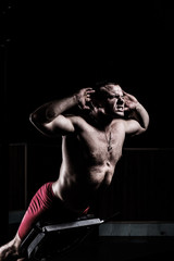 Obraz na płótnie Canvas Bodybuilder is engaged in a simulator in the gym