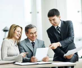 A successful business group discusses a work plan using a tablet