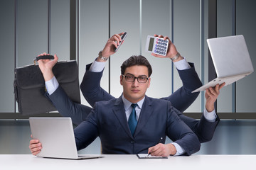 Young businessman in multitasking concept