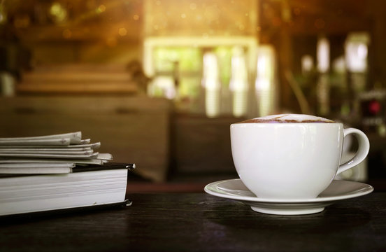 Coffee cup with news paper at coffee shop, summer vintage with sunlight background.