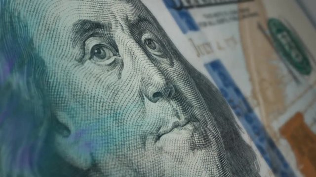 Sir Benjamin Franklin winks at a hundred-dollar bill.