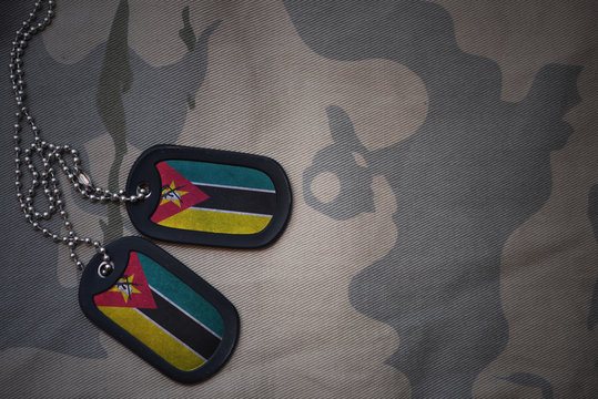 Army Blank, Dog Tag With Flag Of Mozambique On The Khaki Texture Background. Military Concept