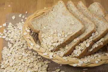Whole wheat bread slices in basket with oats