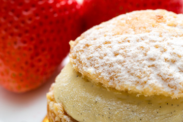 close up of sweet eclaire with fresh strawberries