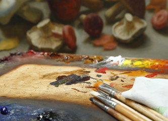 Obraz premium The workplace of the artist, brushes, paints and canvas. Multicolor oil paints on a palette close up.