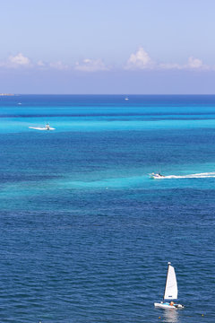 Aerial image of boats sailing on the sea. Yacht, vessel, boat in the turquoise water. Focus point on the sail boat in front right corner.