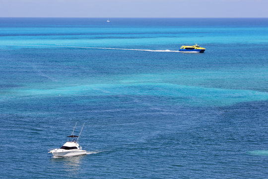 Aerial image of boats sailing on the sea. Yacht, vessel, boat in the turquoise water. Focus point on the white boat.