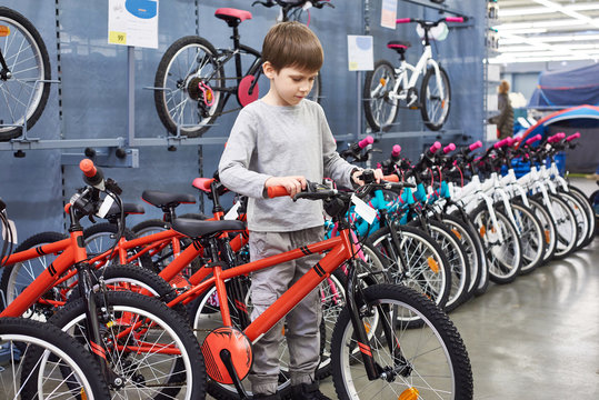 Boy chooses bicycle in sports supermarket