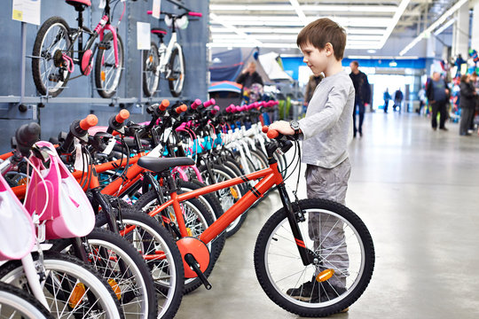 Boy chooses bicycle in sports supermarket