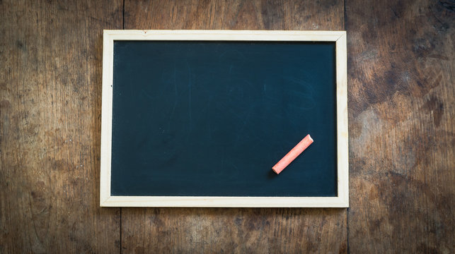 color chalk stick with chalkboard on wooden table