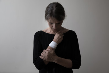 Middle age woman showing her bandaged wrist.