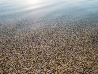 Pebbles under calm clear sea